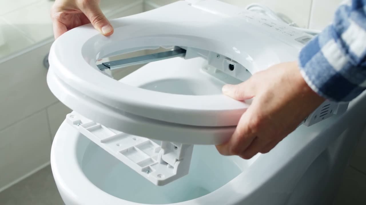 Sample clip poster: hands mounting an electric bidet seat on a toilet bowl